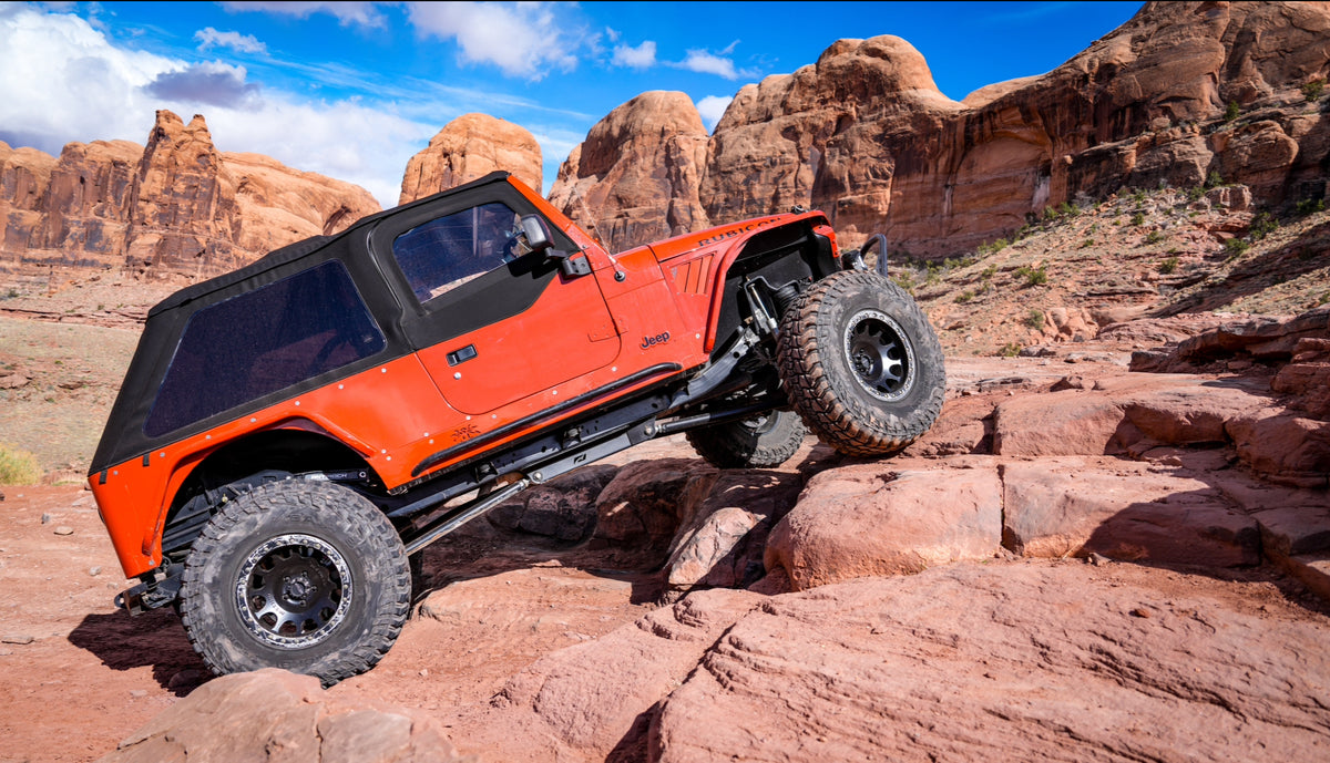 Motobilt 4 Link Suspension Mount Skid System for Jeep TJ / LJ MB1517. Installed in Aarons LJ with Mickey Thompson tires and a Bestop soft top, off-roading in Moab. 